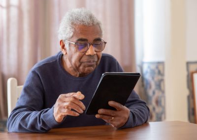 Senior man holding an Ipad while smiling