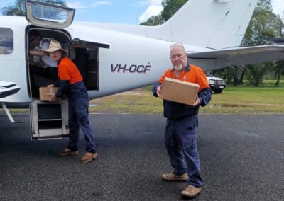 Coen team unloading supplies for the community from a plane.