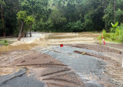 Road with lots of floodwater, and a copious amounts of debris.