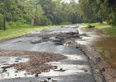 Image shows severely damages road at Rossville / Bloomfield, showcasing the large amounts of road washed away and debris along the road.